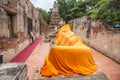 A big sleeping buddha statue cover by orange cloth in an ancient ruins chapel which making from red brick