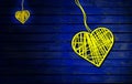 Big and Small Hearts On Rustic Wood Blue dark Background. Heart Shape made By yellows thread hanging with ropes in wooden wall, Royalty Free Stock Photo