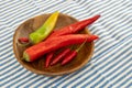 Big and small pod of red and green chili peppers in a wooden plate Royalty Free Stock Photo