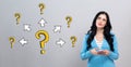 Big and small question marks with arrows with woman holding a smartphone Royalty Free Stock Photo