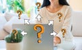 Big and small question marks with arrows with woman using her laptop Royalty Free Stock Photo