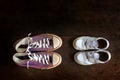 Big and small shoes on wooden floor. Royalty Free Stock Photo