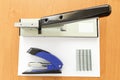 Big and small staplers with staples and paper Royalty Free Stock Photo