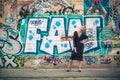 Big smile in of a wall with graffiti. Elegant lady.