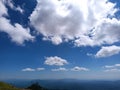 Big soft clouds on the blue sky in summer, below are the mountains Royalty Free Stock Photo