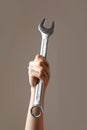 big spanner in the woman& x27;s hand. hand holds a wrench on a gray background. Combination wrench. big chrome vanadium Royalty Free Stock Photo