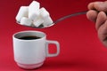 Big spoon of sugar over a cup of coffee