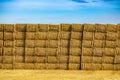 Big stack of rectangular bales of golden hay