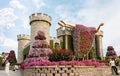 Big stone fairytale castle with a sleeping beauty in botanical Dubai Miracle Garden with different floral fairy-tale themes in Royalty Free Stock Photo