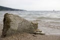 Big stone on the sea shore. Wet sand, transparent water. Overcast cloudy sky. Royalty Free Stock Photo