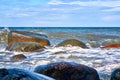 Big stones in the Baltic Sea with foaming waves on the shore Royalty Free Stock Photo