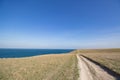 Big stones calm sea, clear sky with clouds skyline and road