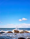 Big stones with foaming waves under blue sky with clouds. Baltic Sea in Mecklenburg-Vorpommern Royalty Free Stock Photo