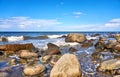 Big stones and waves under blue sky with clouds. Baltic Sea in Mecklenburg-Vorpommern Royalty Free Stock Photo