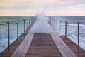 Big stormy waves in the sea through wooden pier. Beautiful seascape with pier. Royalty Free Stock Photo