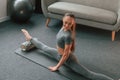 Big stretch for legs. Young woman in yoga clothes doing fitness indoors Royalty Free Stock Photo