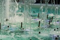 Big and strong water jets from the fountain with blue illumination in shopping center. Splashes and drops. Royalty Free Stock Photo