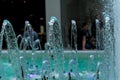 Big and strong water jets from the fountain with blue illumination in shopping center. Splashes and drops. Royalty Free Stock Photo