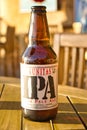 Lagunitas IPA India Pale Ale beer bottle against strong sunlight. Wooden table Royalty Free Stock Photo
