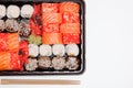 Big sushi set ib black plastic box on white background, top view close up, copy space Royalty Free Stock Photo