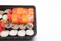 Big sushi set ib black plastic box on white background, top view close up, copy space Royalty Free Stock Photo
