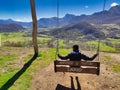 A big swing in pico Caleo, viewpoint over Lario village, MontaÃ±a de RiaÃ±o y Mampodre Regional Park, Leon province, Spain