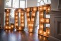 Big tall love capital letters wooden rustic illuminated on dance floor of capitals daytime glowing orange