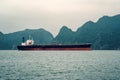 Big tanker anchored in Bay. A large transport ship in the sea against the background of high rocks. Vietnam