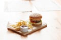 Big tasty burger and fries on the wooden table Royalty Free Stock Photo