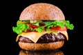 Big tasty hamburger or cheeseburger on black background with grilled meat, cheese, tomato, bacon, onion. Burger closeup Royalty Free Stock Photo