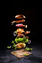 Big tasty home made burger with flying ingredients Royalty Free Stock Photo