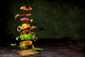 Big tasty home made burger with flying ingredients Royalty Free Stock Photo