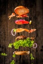 Big tasty home made burger with flying ingredients Royalty Free Stock Photo