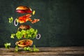 Big tasty home made burger with flying ingredients Royalty Free Stock Photo