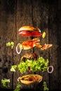 Big tasty home made burger with flying ingredients Royalty Free Stock Photo