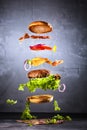 Big tasty home made burger with flying ingredients Royalty Free Stock Photo