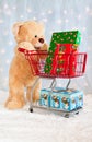 Big teddy bear with shopping cart and presents Royalty Free Stock Photo