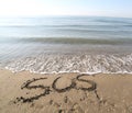 Big text SOS on the sand of the beach Royalty Free Stock Photo