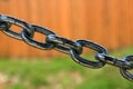 big thick steel dark metal chain links foreground closeup outside