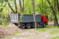 Big tipper truck near soil heap. Reconstruction of city park with heavy machinery Royalty Free Stock Photo