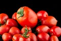 Big tomato and small grape cherry tomatoes on a black background. Low calorie food Royalty Free Stock Photo