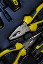 Big tool kit of black and yellow colors for the house in a box. Flat-nose pliers, screw-drivers, stationery knife and nippers. Royalty Free Stock Photo