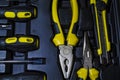 Big tool kit of black and yellow colors for the house in a box. Flat-nose pliers, screw-drivers, stationery knife and nippers. Royalty Free Stock Photo