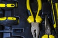 Big tool kit of black and yellow colors for the house in a box. Flat-nose pliers, screw-drivers, stationery knife and nippers. Royalty Free Stock Photo