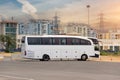 Big tourist buse on parking waiting for passengers on the city street against the backdrop of multi-storey buildings