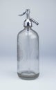 Big transparent glassy bottle with metallic lid on the white background