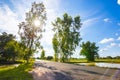 Big tree in little field near the road and blue sky with cloud. Royalty Free Stock Photo