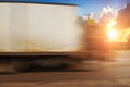 A big truck driving fast on the countryside road in motion with trees and bushes against a sky with sunset Royalty Free Stock Photo