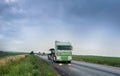 truck driving on a rainy wet highway around fields with headlights reflecting on the road, beautiful scenery with storm