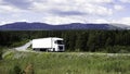 Big trucks moving on a summer road. Scene. Cargo transportation in summer landscapes near a green forest and big Royalty Free Stock Photo